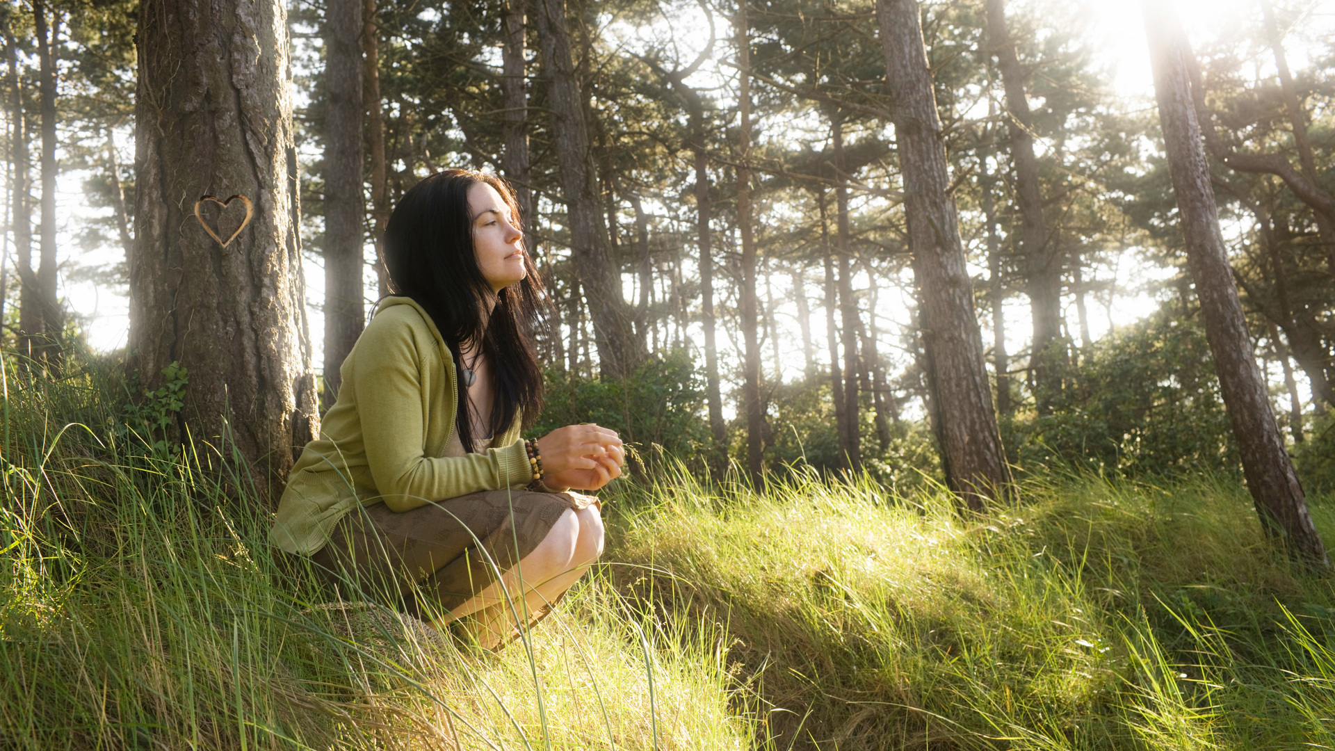 Young woman in front of tree day dreaming